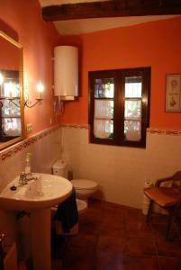 uma casa de banho com um lavatório, um WC e janelas em Molí d'en Pi em Morella