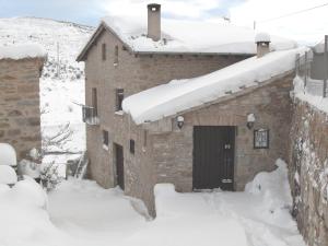 um edifício com uma porta na neve em Molí d'en Pi em Morella