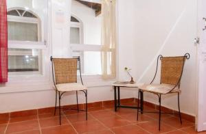 2 chaises et une table dans une chambre avec 2 fenêtres dans l'établissement Hotel Niyati Guest House, à Vieux-Goa