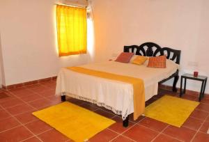 - une chambre avec un lit et 2 tapis jaunes dans l'établissement Hotel Niyati Guest House, à Vieux-Goa