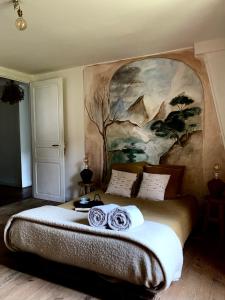 1 dormitorio con 1 cama grande y una pintura en la pared en Abury, tables et chambres , randos et bien être à la montagne, en Barcus
