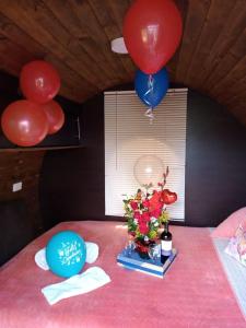 a table with balloons and a vase of flowers on it at Custodiablue in Aquitania