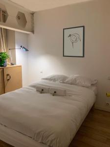 a white bed with two white pillows on it at Design loft in Saint-Denis