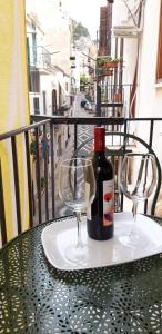 a table with two glasses and a bottle of wine at Bellavista63 in Cefalù