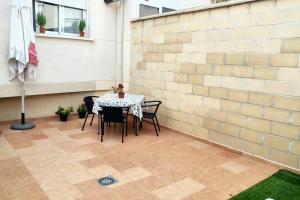 un patio con mesa, sillas y pared en 3 bedrooms house with city view enclosed garden and wifi at Almagro en Almagro