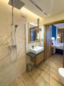 La salle de bains est pourvue d'un lavabo et d'une douche. dans l'établissement MORZE i SZTUKA Apartamenty, à Władysławowo