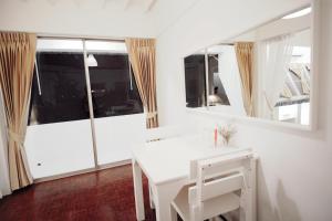 escritorio blanco en una habitación con ventana grande en Vimala Suites en Bangkok