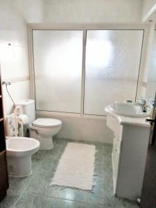 La salle de bains blanche est pourvue de toilettes et d'un lavabo. dans l'établissement 3 bedrooms house with enclosed garden and wifi at Sobral de Monte Agraco, à Sobral de Monte Agraço