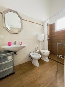 a bathroom with a sink and a toilet and a mirror at Salento apartment in Torre Lapillo