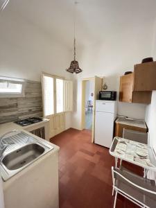 a kitchen with a sink and a stove at Salento apartment in Torre Lapillo +17 photos