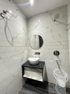 a white bathroom with a sink and a mirror at Hotel The Restu And Restaurant 300 Meter From Golden Temple in Amritsar