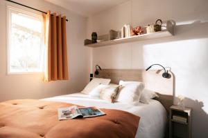 Un dormitorio con una cama con un libro. en Vakantiepark Walsdorf en Fouhren