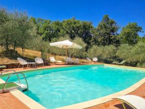 una piscina con sillas y sombrilla en Podere L'Erbolario, stylish villa with private pool and olive garden., en Scrofiano