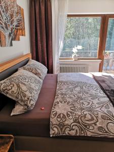 a bed in a bedroom with a large window at Hotel Waldsee in Waldachtal