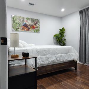 ein Schlafzimmer mit einem Bett und einem Tisch mit einem Bild an der Wand in der Unterkunft The Luxurious loft in Newark