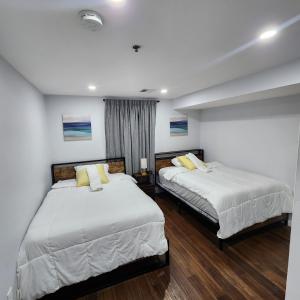 2 Betten in einem Zimmer mit weißen Wänden und Holzböden in der Unterkunft The Luxurious loft in Newark
