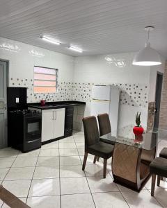 a kitchen with a table and chairs in a room at Casa espaçosa e aconchegante Jphouse in São José