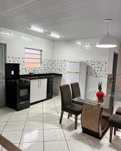 a kitchen with a table and chairs in a room at Casa espaçosa e aconchegante Cama King e ar condicionado in São José +13 photos