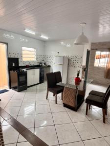 a large kitchen with a glass table and chairs at Casa espaçosa e aconchegante Cama King e ar condicionado in São José