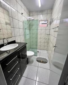 a bathroom with a toilet and a sink and a shower at Casa espaçosa e aconchegante Jphouse in São José