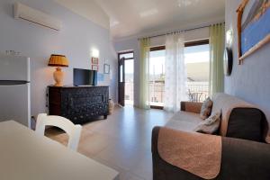 un soggiorno con divano e TV di CASA AZZURRA - BLUE HOUSE a Teulada