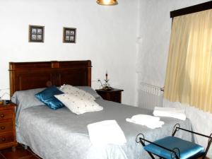 um quarto com uma cama e uma cadeira azul em Molí d'en Pi em Morella