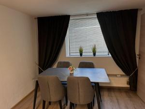 a dining room table with chairs and a window at Comfortable 2 Bedroom Apartment Stuttgart &Ulm Area in Kuchen