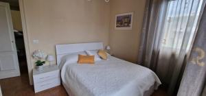 1 dormitorio con 1 cama con almohadas de color naranja y ventana en Appartamento Le Rose, en Viareggio