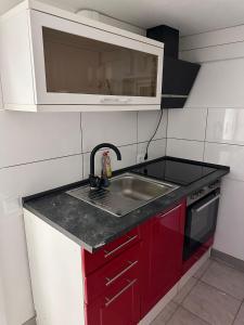 a small kitchen with a sink and a microwave at Zwei Zimmer Wohnung mit Küche in Kuchen