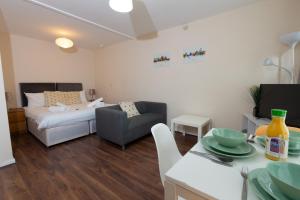 un piccolo soggiorno con letto e tavolo di Centrally Located 1Bed Apt in Stretford a Manchester