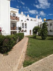 a large white building with a walkway in front of it at Tavira Garden Oasis in Tavira