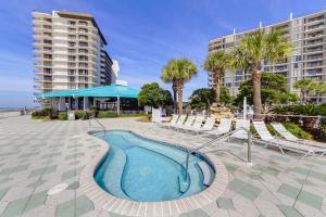 a swimming pool in a resort with palm trees and buildings at Edgewater Tower 2-108-Gunners Paradise in Panama City Beach
