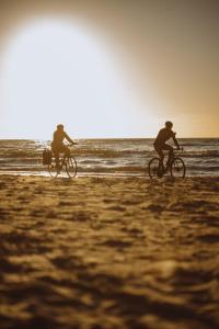 Dos personas en bicicleta en la playa en Boho Sfera, en Kopalino