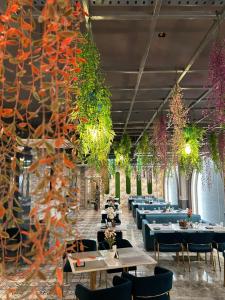 a dining room with tables and chairs and plants at Royal Chandra Hotel in Patna