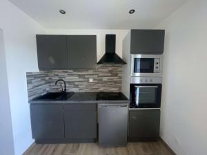a kitchen with a sink and a stove top oven at Jiovanni in Rieux-Minervois