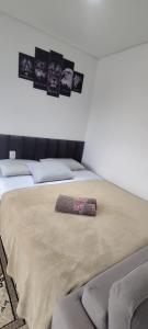 uma cama com um cobertor com fotografias na parede em La Home House1 - Apto Studio Confortável em SJP - 10 minutos Aeroporto - Curitiba em São José dos Pinhais