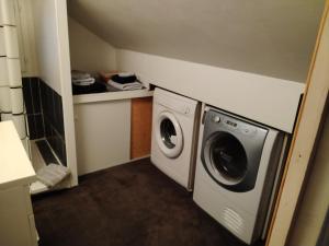 - un lave-linge et un sèche-linge dans une petite pièce dans l'établissement " LA DORDOGNE" appartement en duplex dans maison individuelle, à Le Mont-Dore