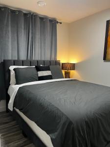 a bedroom with a large bed with gray sheets at Cozy Haven! in Edmonton