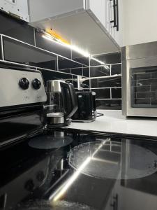 a kitchen with a stove and a microwave at Cozy Haven! in Edmonton