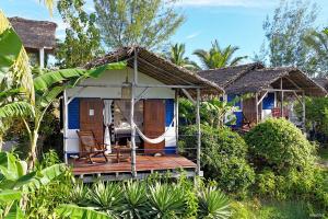 a small blue and white house with a porch at Le Grand Bleu in Andilana