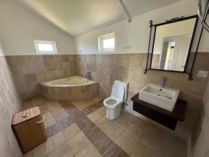 uma casa de banho com uma banheira, um WC e um lavatório. em Villa Piefraper em Grand Gaube