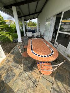 patio ze stołem i krzesłami na domu w obiekcie Villa Piefraper w mieście Grand Gaube