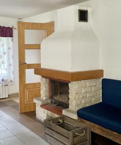 a living room with a fireplace with a blue couch at Siedlisko Dąb w Lubogoszczy koło Sławy in Sława