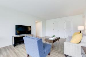a living room with a couch and a tv at 2BR Executive Apartment with Spacious Layout in Arlington