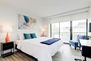 Biała sypialnia z dużym łóżkiem i biurkiem w obiekcie 2BR Executive Apartment with Spacious Layout w mieście Arlington
