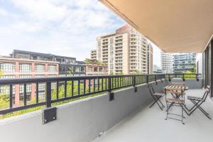 balcone con 2 sedie e un tavolo sopra di 2BR Executive Apartment with Spacious Layout ad Arlington