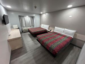 um quarto de hotel com duas camas e uma televisão em Motel 6 Idabel, OK em Idabel