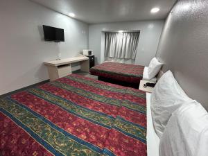 ein Hotelzimmer mit 2 Betten und einem Schreibtisch in der Unterkunft Motel 6 Idabel, OK in Idabel