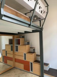 a loft bed with wooden shelves in a room at Design loft in Saint-Denis