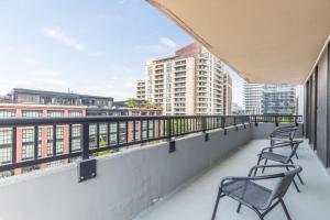 two chairs on a balcony with a view of buildings at 2BR Comfort Apartment in Prime Location in Arlington